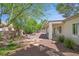Well-maintained backyard with stone pathway, desert landscaping, and covered patio area at 2292 Saxtons River Rd, Henderson, NV 89044