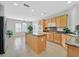 Well-lit kitchen with wood cabinets, granite countertops, and an island with breakfast bar seating at 2292 Saxtons River Rd, Henderson, NV 89044