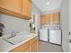 Convenient laundry room with sink, cabinets, and modern washer and dryer units at 2292 Saxtons River Rd, Henderson, NV 89044