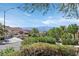 Street view of a neighborhood with well-maintained homes, mature trees, and mountain backdrop at 2292 Saxtons River Rd, Henderson, NV 89044