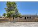 Home exterior featuring large tree, neutral paint, black trim and a concrete block fence in front at 2315 Lincoln Rd, Las Vegas, NV 89115