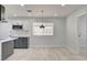 Bright kitchen area with modern lighting, white cabinets, stainless steel appliances, and light-colored wood floor at 2315 Lincoln Rd, Las Vegas, NV 89115