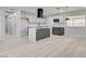 Open kitchen with modern island, white cabinets, stainless steel appliances, and contemporary vent hood at 2315 Lincoln Rd, Las Vegas, NV 89115