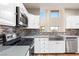 Modern kitchen with stainless steel appliances, white cabinetry, and a tiled backsplash at 251 Big Horn Dr, Boulder City, NV 89005