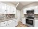 Well-lit kitchen with white cabinets, stainless steel appliances, and stylish backsplash at 251 Big Horn Dr, Boulder City, NV 89005
