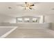 Bright and airy loft area with carpeted flooring, ceiling fan, and scenic views through windows at 251 Big Horn Dr, Boulder City, NV 89005