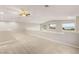 Spacious loft area with carpeted flooring, a ceiling fan, and scenic views from multiple windows at 251 Big Horn Dr, Boulder City, NV 89005