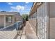 Sideways view of a single-story house with chain link fencing and trash bins at 2528 Sunrise Ave, Las Vegas, NV 89101