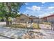 View of a single-story house with chain link fencing, some landscaping, and a large tree providing shade at 2528 Sunrise Ave, Las Vegas, NV 89101