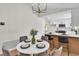 Bright dining area with a modern chandelier, table setting, and views into the updated kitchen with an island at 2532 Big Timber Dr, Las Vegas, NV 89134