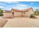 Tan stucco home featuring a red tile roof, concrete driveway, and desert landscaping at 2532 Big Timber Dr, Las Vegas, NV 89134
