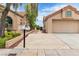 View of home's front exterior featuring a 2 car garage, mature landscaping, and a spacious front yard at 2532 Big Timber Dr, Las Vegas, NV 89134
