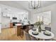 Open-concept kitchen and dining area featuring white cabinets, stainless steel appliances, and modern light fixtures at 2532 Big Timber Dr, Las Vegas, NV 89134