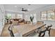 Open floor plan with dining area and living room featuring large windows, wood floors, and modern furnishings at 2532 Big Timber Dr, Las Vegas, NV 89134