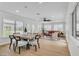 Open floor plan with dining area and living room featuring large windows, wood floors, and modern furnishings at 2532 Big Timber Dr, Las Vegas, NV 89134