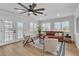 Bright living room with large windows, hardwood floors, modern furniture, and a ceiling fan at 2532 Big Timber Dr, Las Vegas, NV 89134