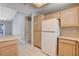 View of the kitchen featuring wood cabinets, a white refrigerator and tile flooring at 2851 S Valley View Blvd # 1039, Las Vegas, NV 89102