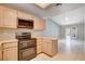 Kitchen features wood cabinets, stainless appliances, and tile flooring, with an adjoining living area at 2851 S Valley View Blvd # 1039, Las Vegas, NV 89102