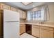 Bright kitchen featuring wood cabinets, light countertops, stainless steel sink and white refrigerator at 2851 S Valley View Blvd # 1039, Las Vegas, NV 89102