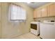 Functional laundry room with a modern dryer and washer setup, complemented by overhead storage cabinets and natural light at 2851 S Valley View Blvd # 1039, Las Vegas, NV 89102