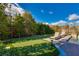 Backyard putting green with lounge chairs and mature trees at 30 Meadowhawk Ln, Las Vegas, NV 89135