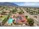 Scenic aerial shot of a home with a large pool, spa, solar panels, and mountain views in the distance at 301 E Longacres Dr, Henderson, NV 89015