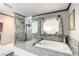 Luxurious bathroom with a stand-alone shower, soaking tub, and stylish decor at 301 E Longacres Dr, Henderson, NV 89015