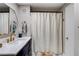 Well-lit bathroom with white countertops, gold hardware, and a shower curtain at 301 E Longacres Dr, Henderson, NV 89015