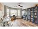 Bright bedroom featuring hardwood floors, a ceiling fan, and built-in blue bookshelves at 301 E Longacres Dr, Henderson, NV 89015