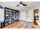Well-lit bedroom with hardwood floors, ceiling fan, a large closet, and built-in bookshelves at 301 E Longacres Dr, Henderson, NV 89015