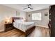 Cozy bedroom with hardwood floors, ceiling fan, and natural light from the window at 301 E Longacres Dr, Henderson, NV 89015