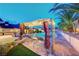 Lounge by the pool with a shaded cabana and lush landscaping at 301 E Longacres Dr, Henderson, NV 89015