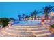 Stunning pool area with mature palm trees, rock features, and tiered access at 301 E Longacres Dr, Henderson, NV 89015