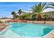 Refreshing in-ground pool with a unique design, surrounded by mature palm trees and rock landscaping at 301 E Longacres Dr, Henderson, NV 89015