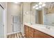 Bathroom featuring double sinks, wood cabinets, and a glass-enclosed shower with wood-look vinyl flooring at 3307 Forestina Ct, Las Vegas, NV 89122