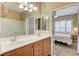 Bright bathroom featuring dual sinks, wood cabinets, large mirrors and a shower with glass enclosure at 3307 Forestina Ct, Las Vegas, NV 89122