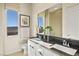 Bright bathroom featuring double sinks, white cabinets, and a large window with a view at 344 Tigullio Ave, Henderson, NV 89011