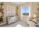 Cozy Bedroom with neutral tones, a crib, chair, and a window providing natural light at 344 Tigullio Ave, Henderson, NV 89011