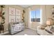 Cozy Bedroom with neutral tones, a crib, chair, and a window providing natural light at 344 Tigullio Ave, Henderson, NV 89011