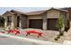 Charming single-story home with a two-car garage, beautiful stone accents, and decorative front yard benches at 344 Tigullio Ave, Henderson, NV 89011