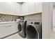 Well-appointed laundry area with ample storage, contemporary machines, and stylish tile accents at 344 Tigullio Ave, Henderson, NV 89011