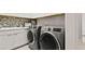 Functional laundry room boasting sleek cabinetry, modern washer and dryer, and attractive backsplash at 344 Tigullio Ave, Henderson, NV 89011