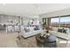 Open-concept living room with a view of the kitchen, dining area, and large sliding doors to outdoor space at 344 Tigullio Ave, Henderson, NV 89011