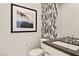 Stylish powder room featuring unique tile accent wall and modern vanity with eye-catching framed art at 344 Tigullio Ave, Henderson, NV 89011