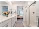 Bright bathroom featuring double sinks, a tiled shower, and a view into the Primary bedroom at 3782 Neblina Dr, Henderson, NV 89052