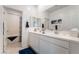 Bright bathroom featuring a double sink vanity, large mirror and tub with a blue patterned shower curtain at 3782 Neblina Dr, Henderson, NV 89052