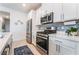 Kitchen with stainless steel appliances, white cabinetry, and marble countertops at 3782 Neblina Dr, Henderson, NV 89052