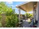 Charming covered patio with brick flooring, outdoor furniture, and a lush landscaped garden at 3782 Neblina Dr, Henderson, NV 89052