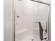 Clean, white tiled shower with glass door, built-in bench, and modern fixtures at 3782 Neblina Dr, Henderson, NV 89052