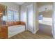 Bathroom with tub, glass block window, and marble accents at 379 Marlin Cove Rd, Henderson, NV 89012